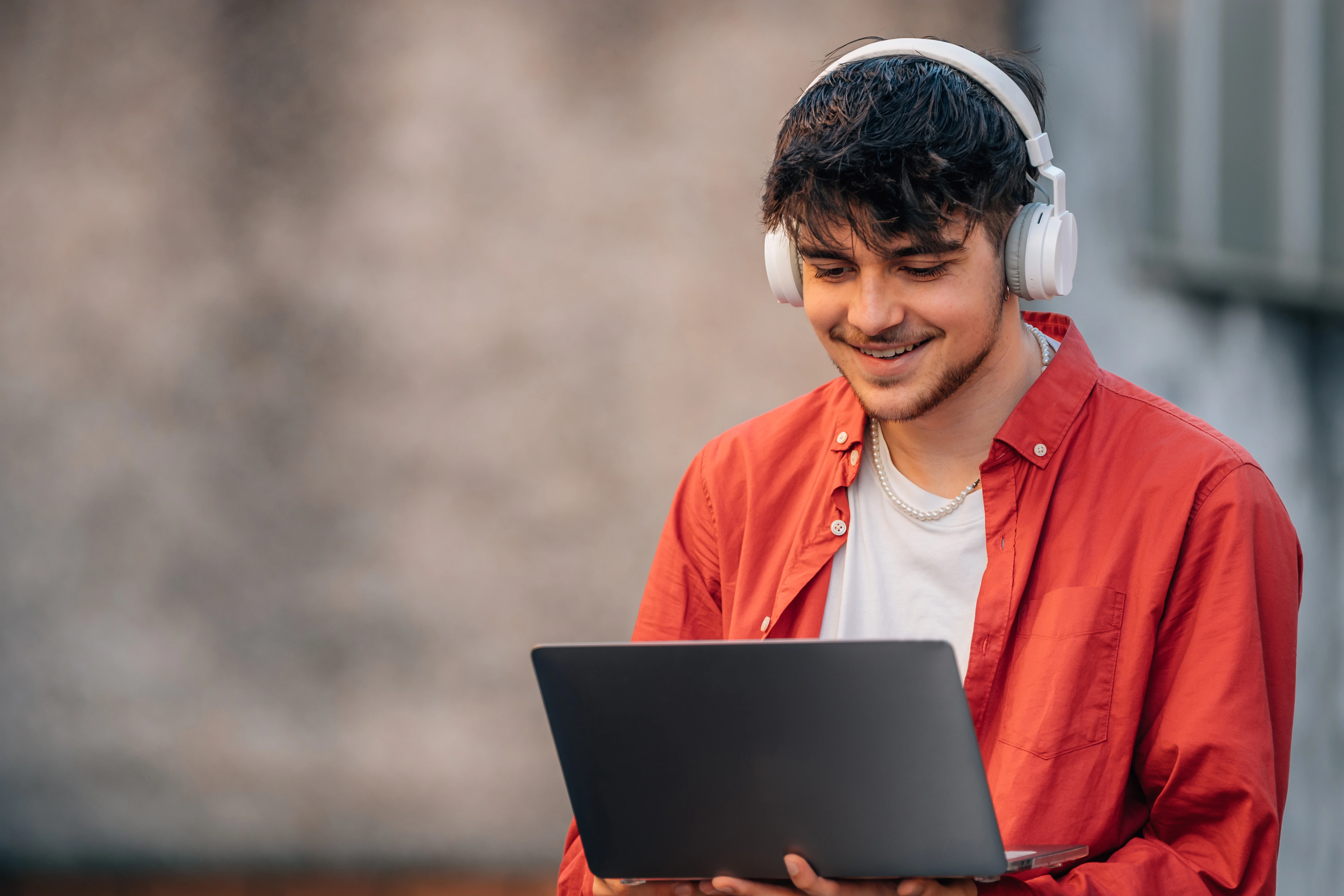 Young man on laptop wearing headphones