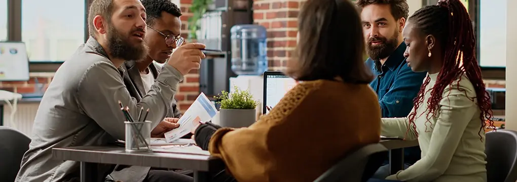 Diverse group of people discussing around a table.