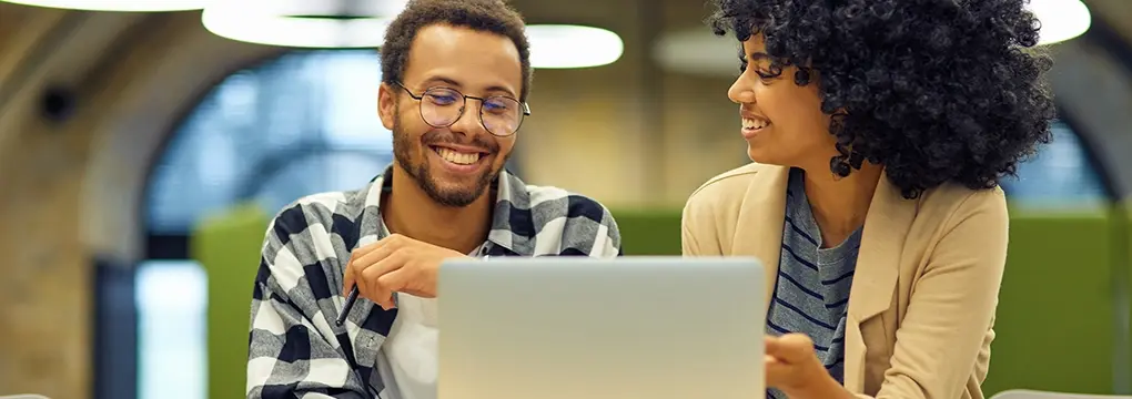 Two people working on a laptop