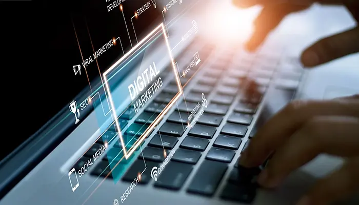 Hands typing on laptop with graphic digital strategy overlay.