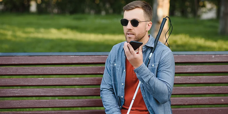 FIREANT STUDIO showing the importance of creating an Accessibility statement - image of blind man on bench with phone