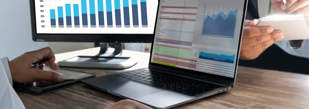 Laptop showing data next to a chart in an office setting