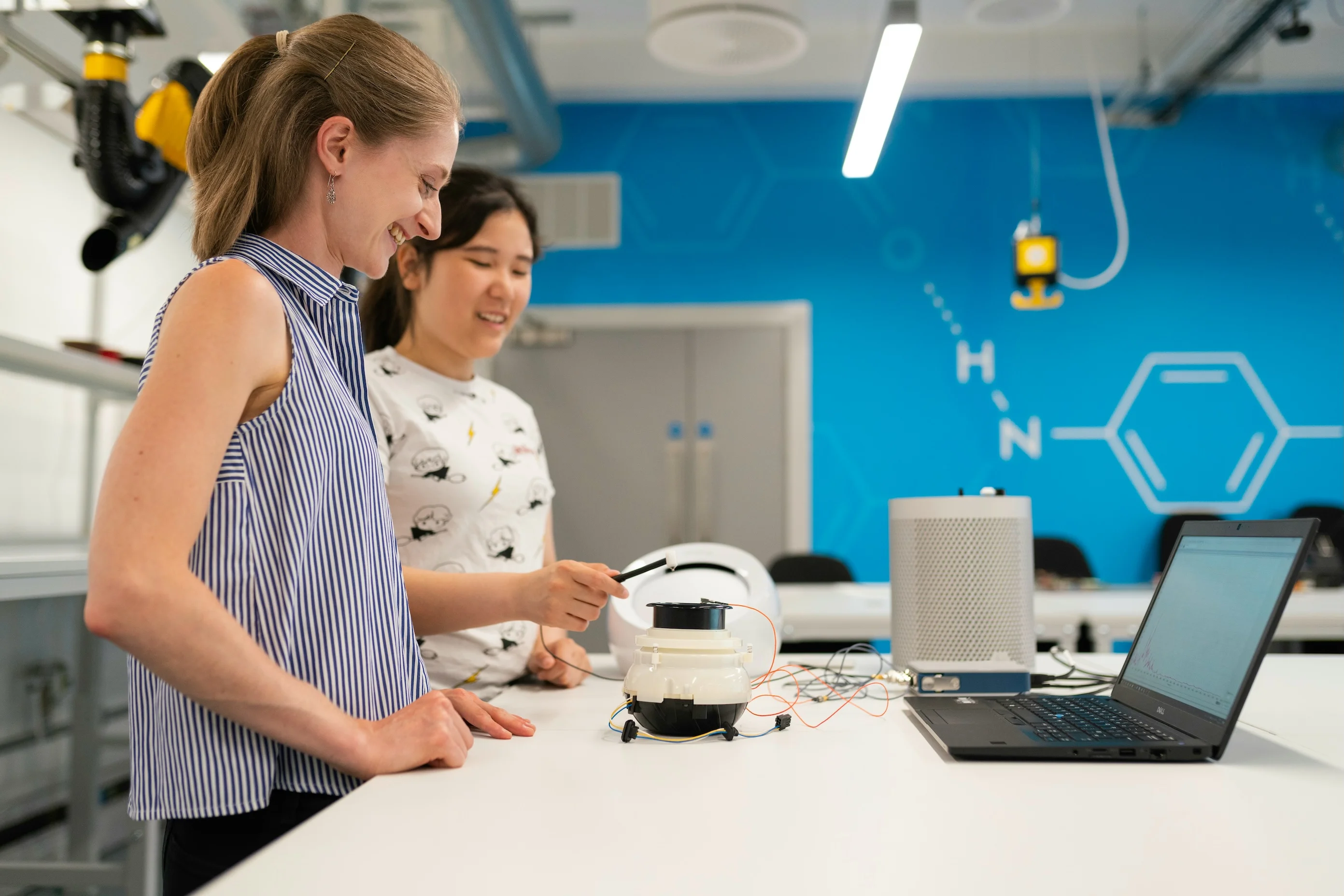 Two women working on high tech accessible robotics projects in a university lab.